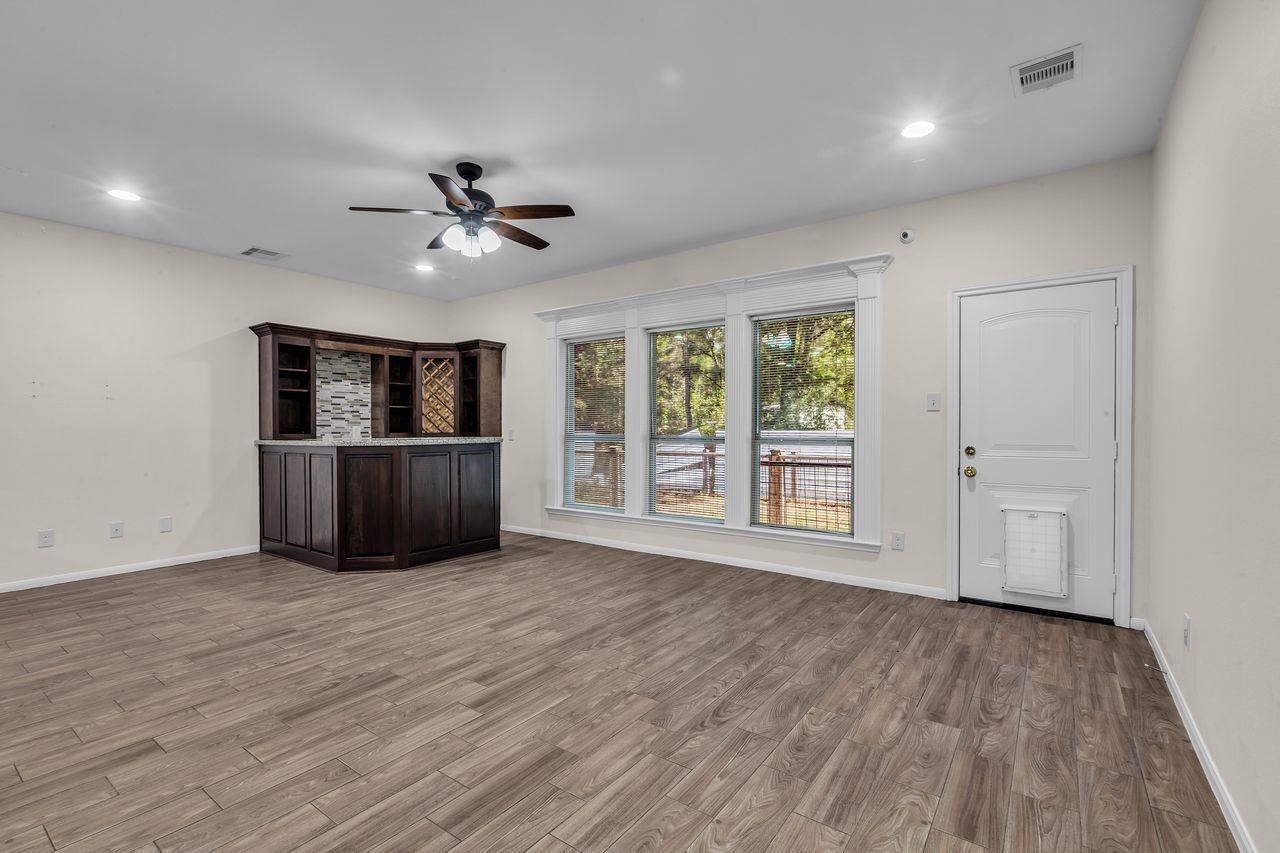 25171 Virginia Lane Porter, TX 77365 - Photo 17 of 39 a view of a livingroom with wooden floor a ceiling fan and windows