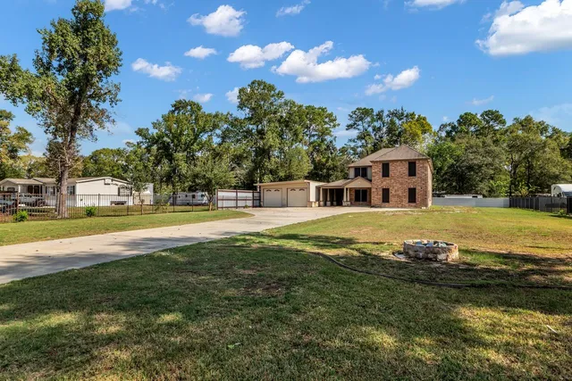 a view of house with swimming pool and yard