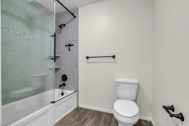 a white toilet sitting next to a bath tub and a shower