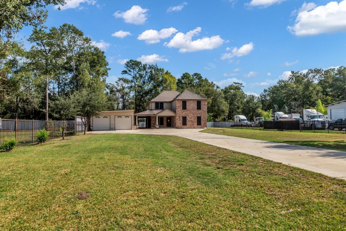25171 Virginia Lane Porter, TX 77365 - Photo 4 of 39 a house view with swimming pool and trees in the background