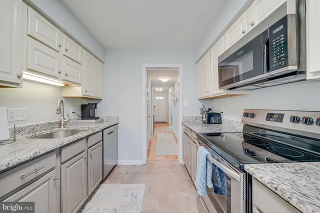 a kitchen with stainless steel appliances granite countertop a refrigerator and a sink