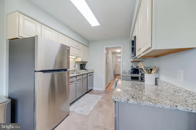 a kitchen with stainless steel appliances granite countertop a refrigerator and a stove top oven