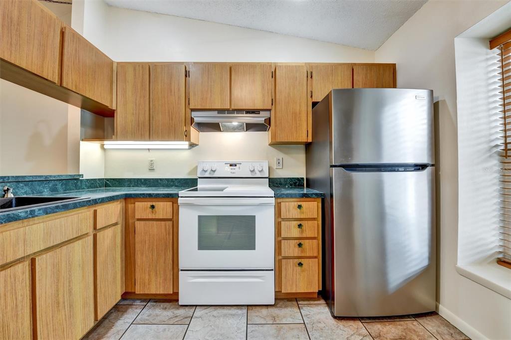 558 Capistrano Court Largo, FL 33771 - Photo 13 of 40 a kitchen with stainless steel appliances granite countertop a refrigerator and a stove