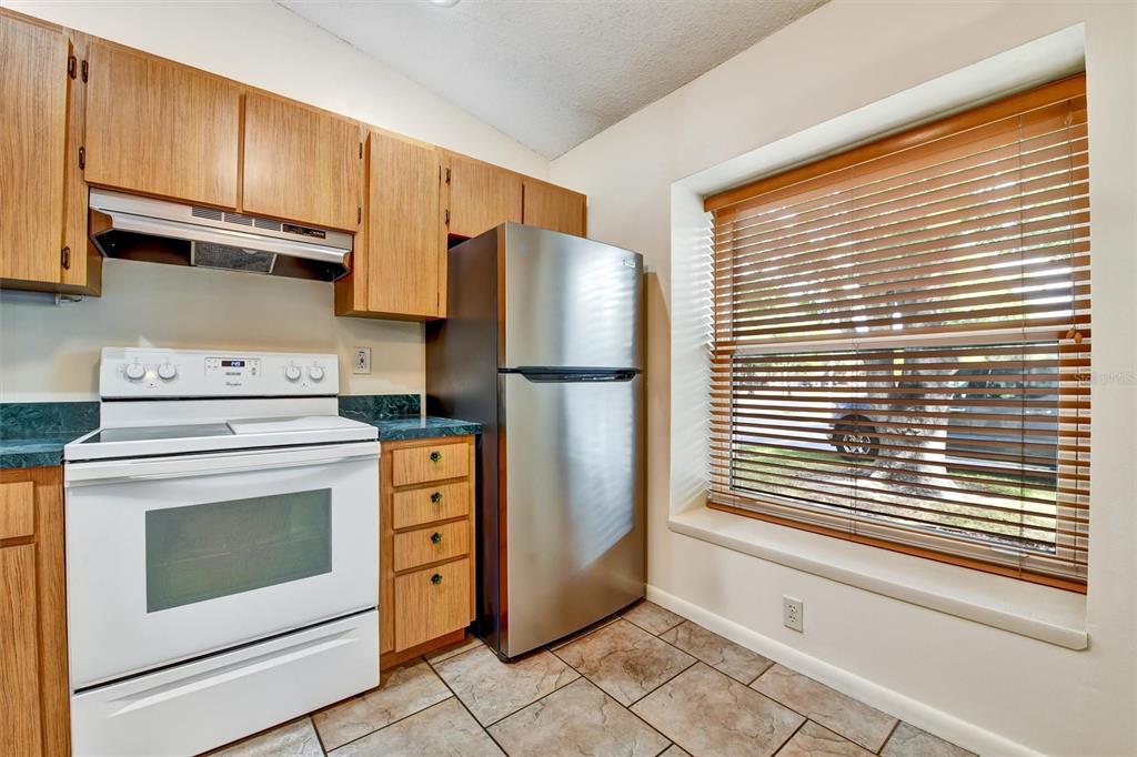 558 Capistrano Court Largo, FL 33771 - Photo 14 of 40 a kitchen with stainless steel appliances granite countertop a refrigerator and a stove