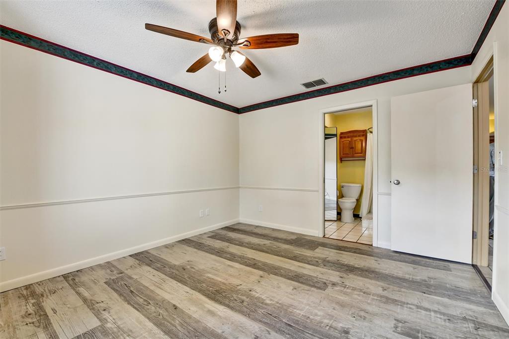 558 Capistrano Court Largo, FL 33771 - Photo 17 of 40 a view of a livingroom with a ceiling fan and wooden floor