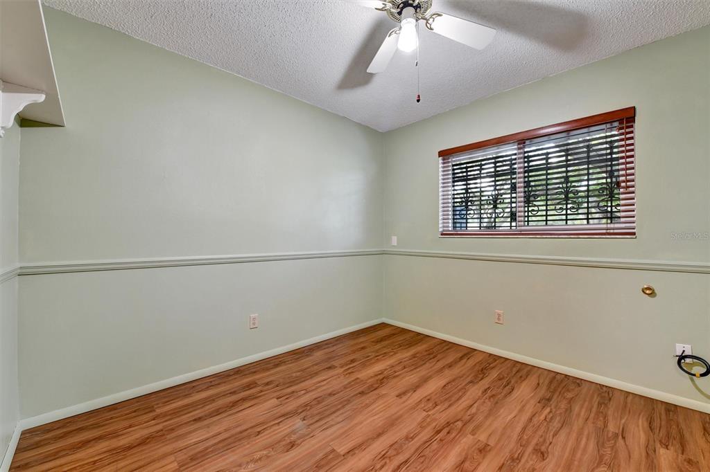 558 Capistrano Court Largo, FL 33771 - Photo 22 of 40 a view of empty room with wooden floor and fan