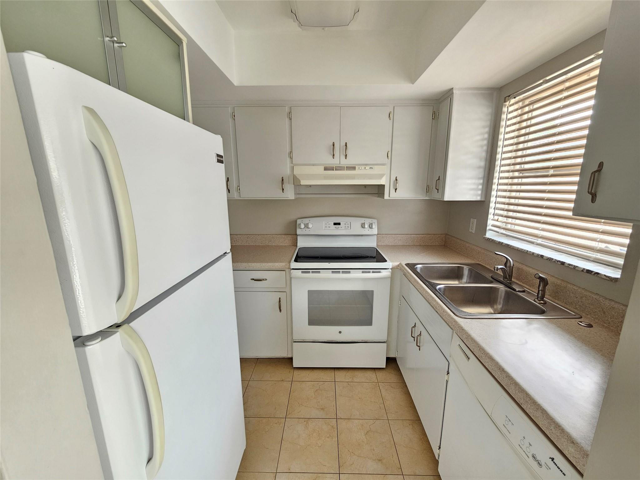 2120 Northeast 41st Street, Unit B Lighthouse Point, FL 33064 - Photo 11 of 24 a kitchen with a refrigerator sink stove and cabinets