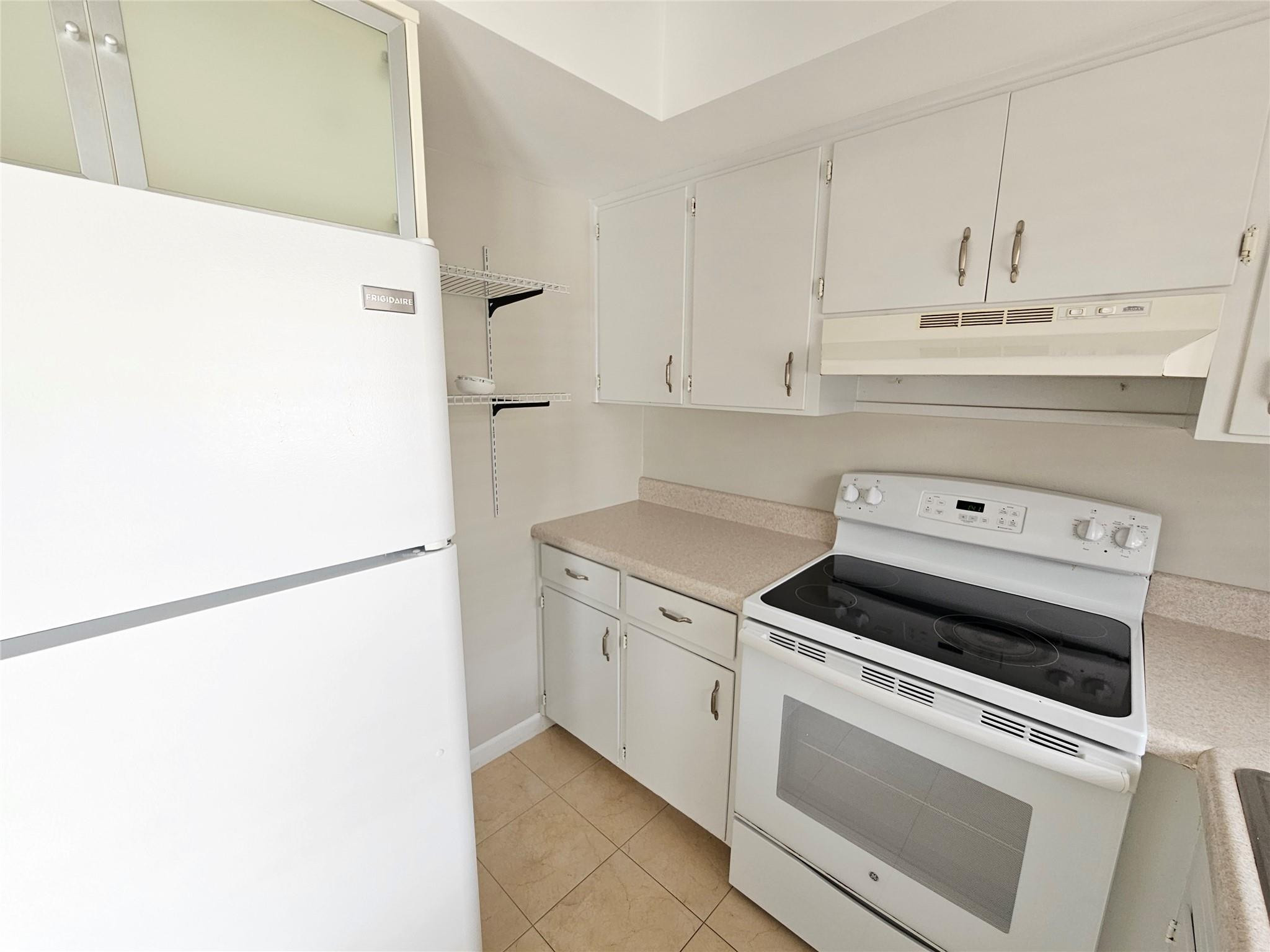 2120 Northeast 41st Street, Unit B Lighthouse Point, FL 33064 - Photo 12 of 24 a white stove top oven sitting inside of a kitchen