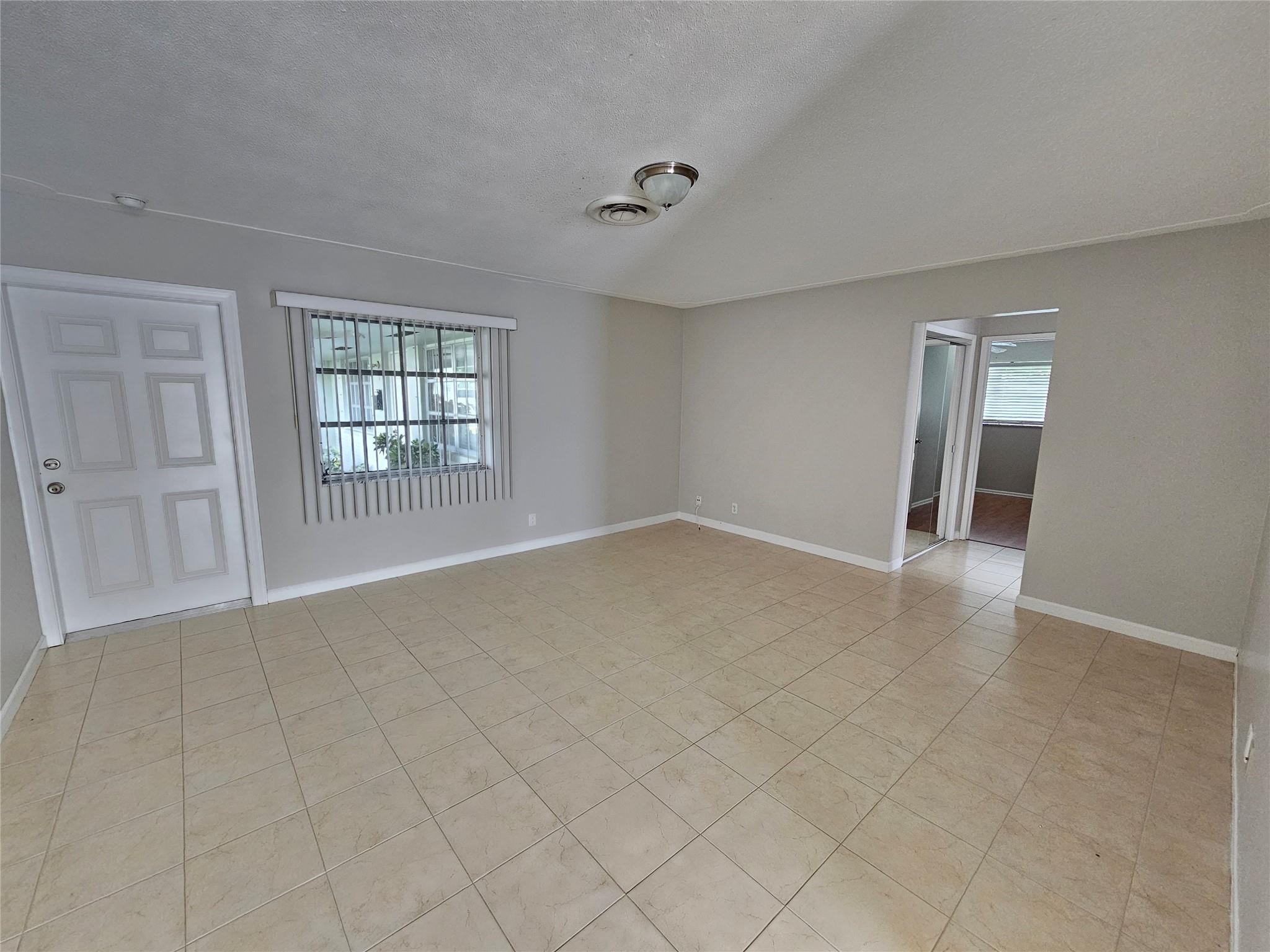 2120 Northeast 41st Street, Unit B Lighthouse Point, FL 33064 - Photo 13 of 24 an empty room with windows and closet