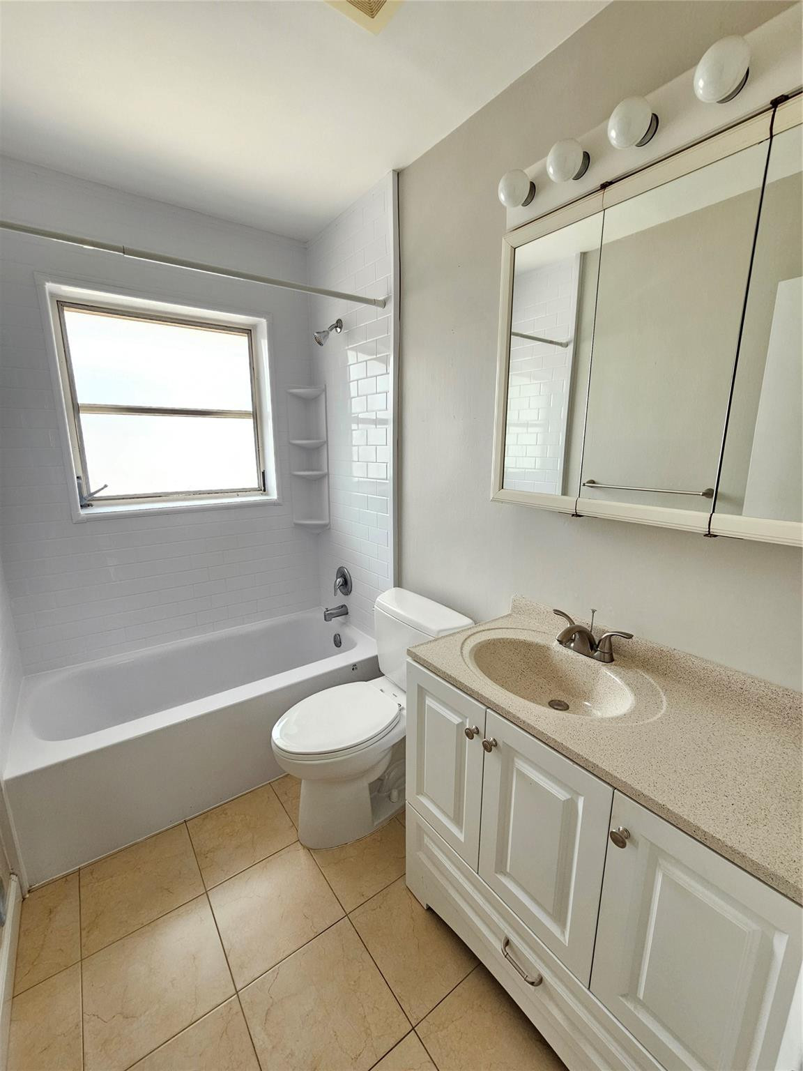2120 Northeast 41st Street, Unit B Lighthouse Point, FL 33064 - Photo 17 of 24 a bathroom with a double vanity sink a mirror and a bathtub