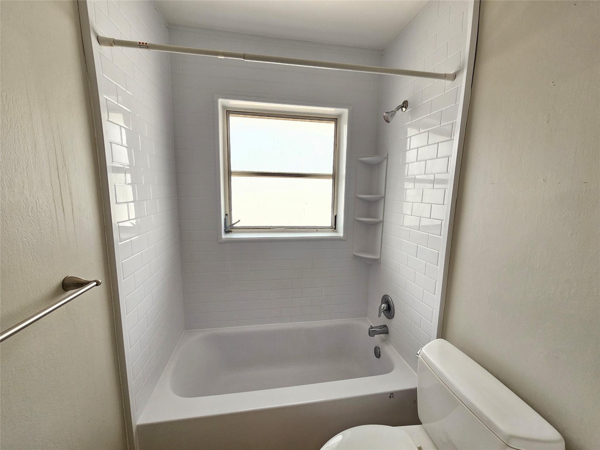 2120 Northeast 41st Street, Unit B Lighthouse Point, FL 33064 - Photo 18 of 24 a bathroom with a bathtub and window