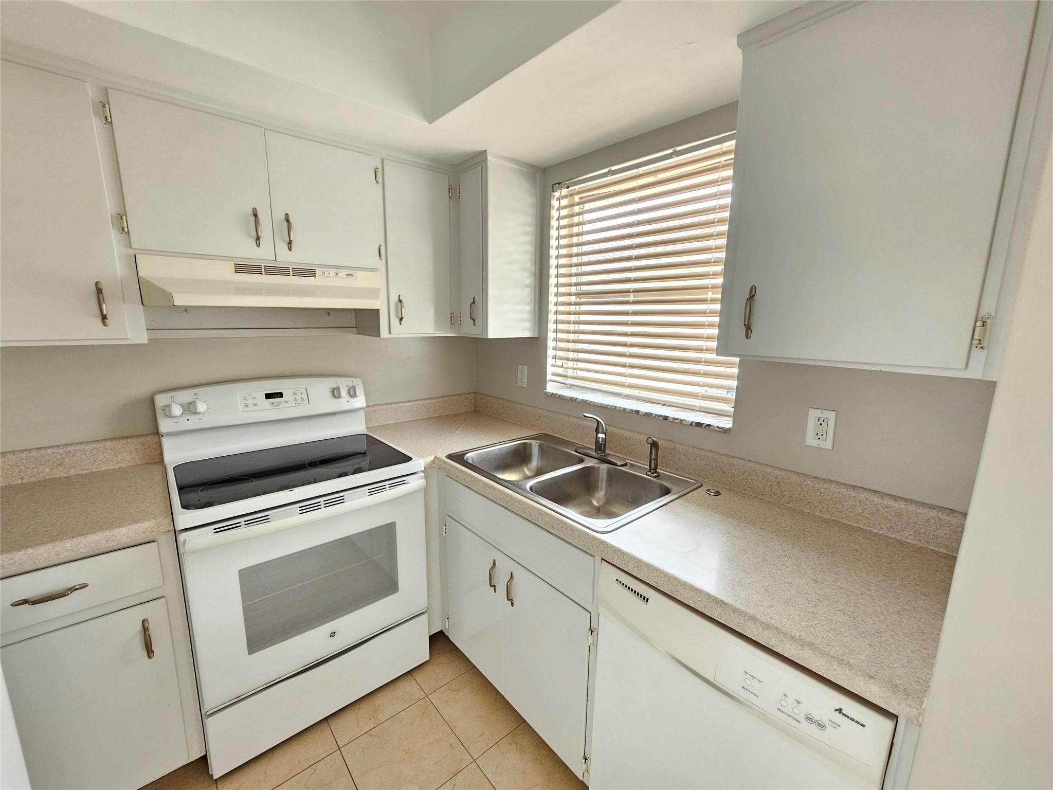 2120 Northeast 41st Street, Unit B Lighthouse Point, FL 33064 - Photo 5 of 24 a kitchen with granite countertop white cabinets and white appliances