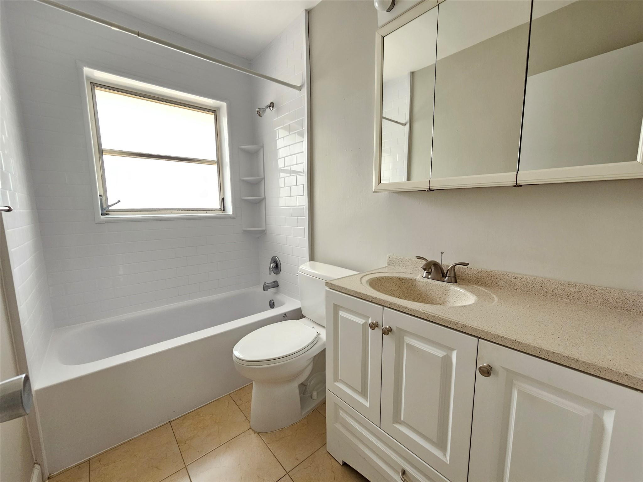 2120 Northeast 41st Street, Unit B Lighthouse Point, FL 33064 - Photo 9 of 24 a bathroom with a sink toilet and tub