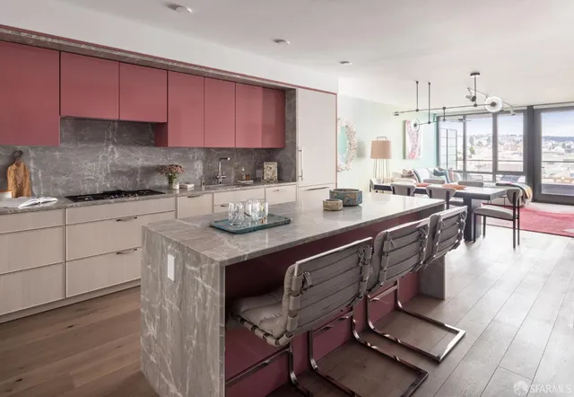 a kitchen with a sink a stove cabinets and wooden floor
