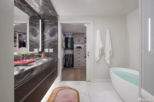 a living room with stainless steel appliances furniture a rug and a view of kitchen