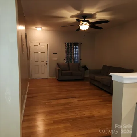 a living room with furniture and a ceiling fan