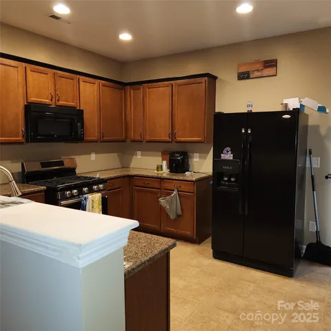 a kitchen with a refrigerator and a stove top oven