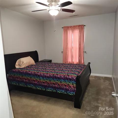 a bed sitting in a bedroom next to a window