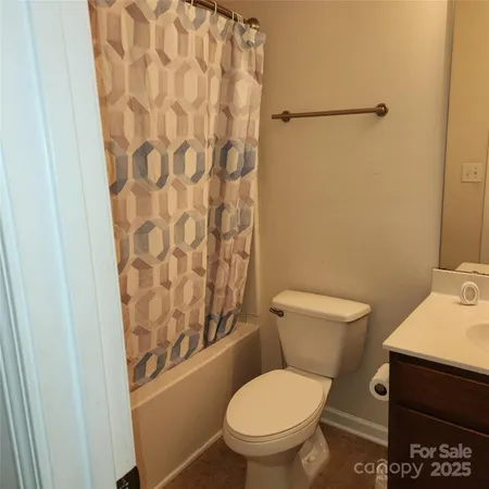 a white toilet sitting next to a shower curtain