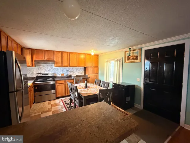 a kitchen with stainless steel appliances kitchen island granite countertop a refrigerator and stove