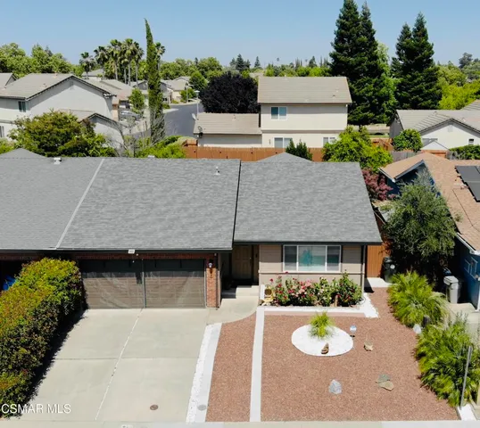 an aerial view of a house with swimming pool and a yard