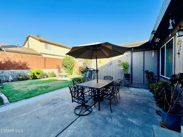 a view of a patio with a table and chairs under an umbrella