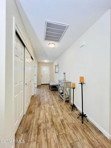 a view of a room with gym equipment and wooden floor