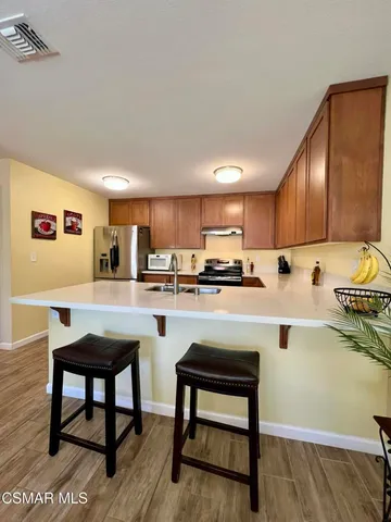 a kitchen with a table chairs microwave and cabinets