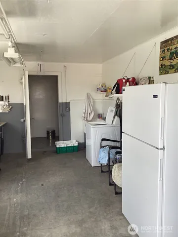a utility room with refrigerator and washer