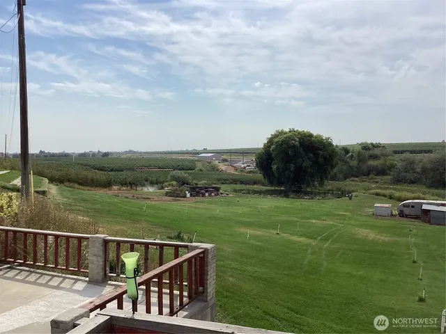 a view of a green field with sitting area