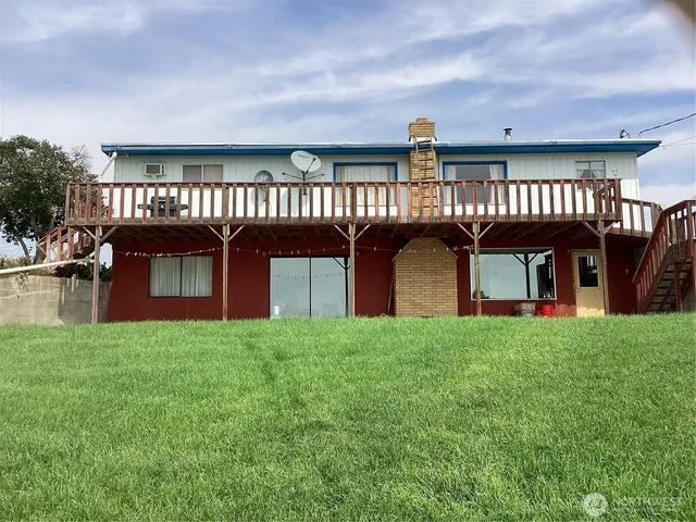 a view of a house with a big yard and large trees
