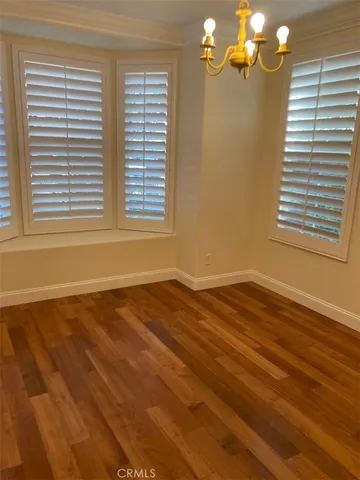 a view of a livingroom with wooden floor and a window