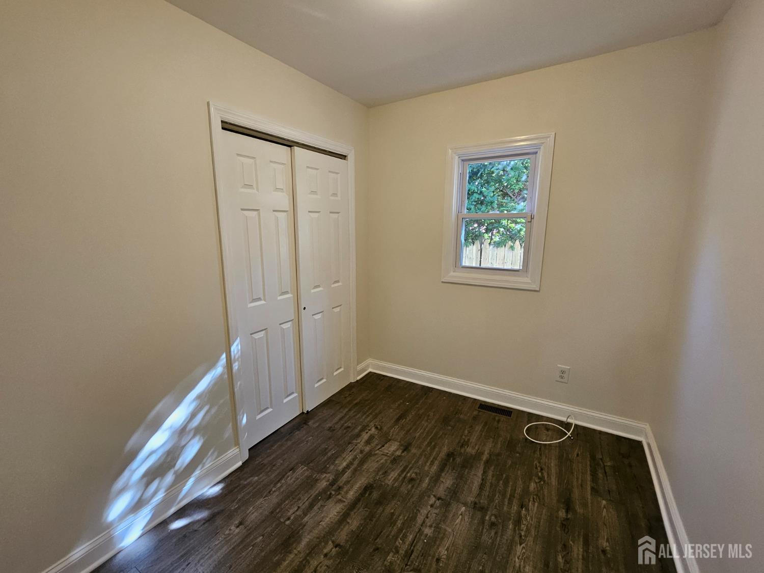 60 6th Avenue Trenton, NJ 08619 - Photo 11 of 28 a view of an empty room with wooden floor and a window