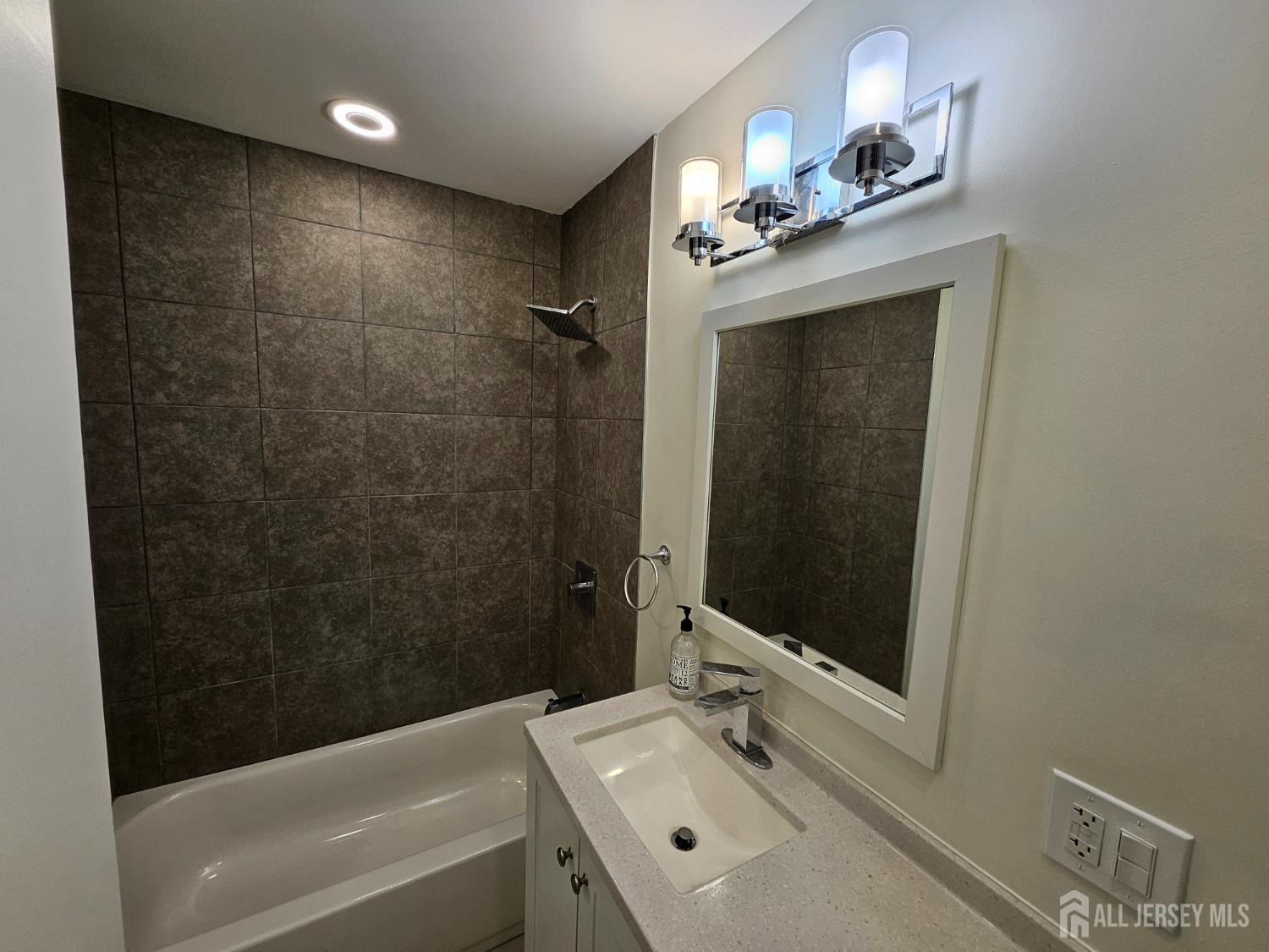 60 6th Avenue Trenton, NJ 08619 - Photo 12 of 28 a bathroom with a tub a sink and mirror