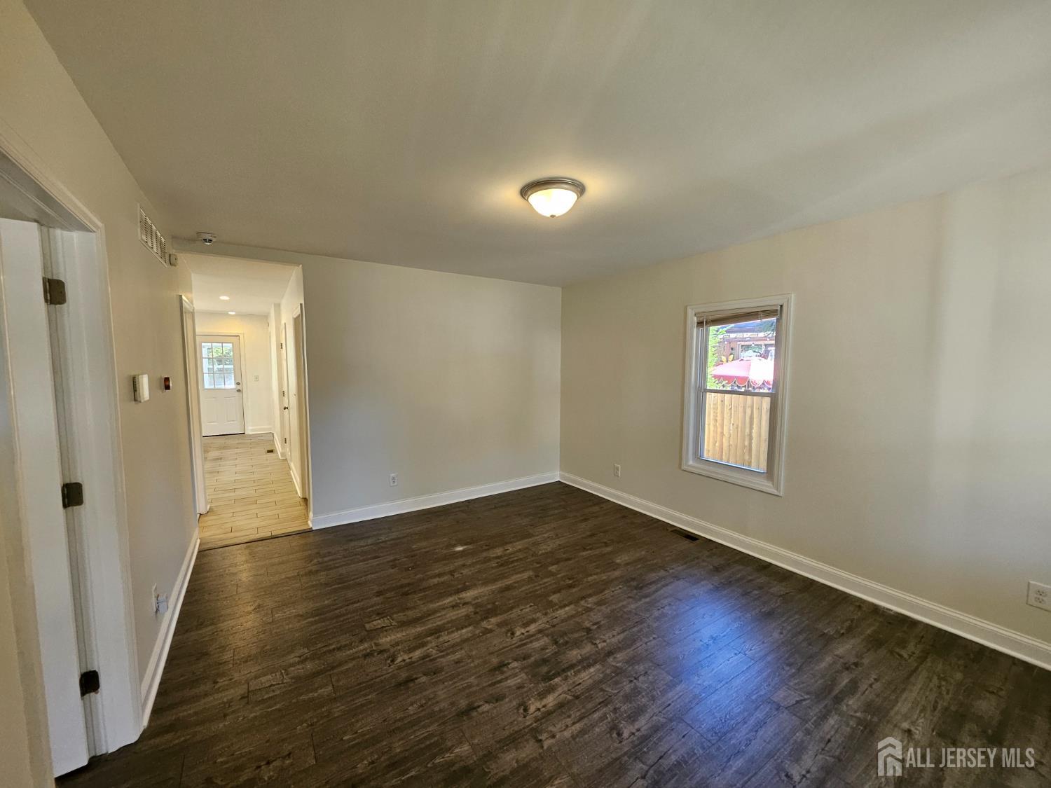 60 6th Avenue Trenton, NJ 08619 - Photo 8 of 28 a view of an empty room with wooden floor and a window