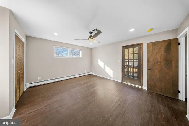 a view of a livingroom with wooden floor and a ceiling fan