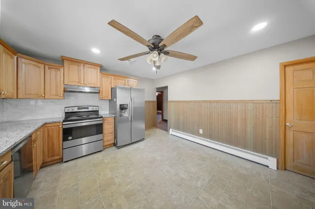 a kitchen with granite countertop a refrigerator oven a sink and dishwasher