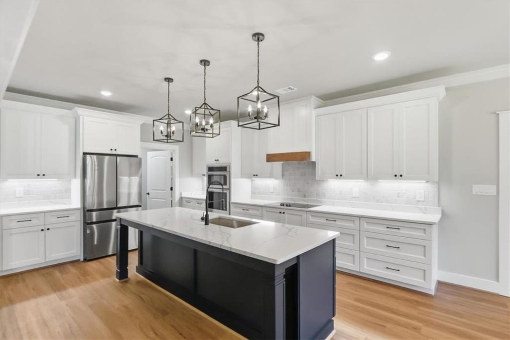 1217 Pleasant Valley Road Monroe, GA 30655 - Photo 5 of 8 a kitchen with center island white cabinets and stainless steel appliances