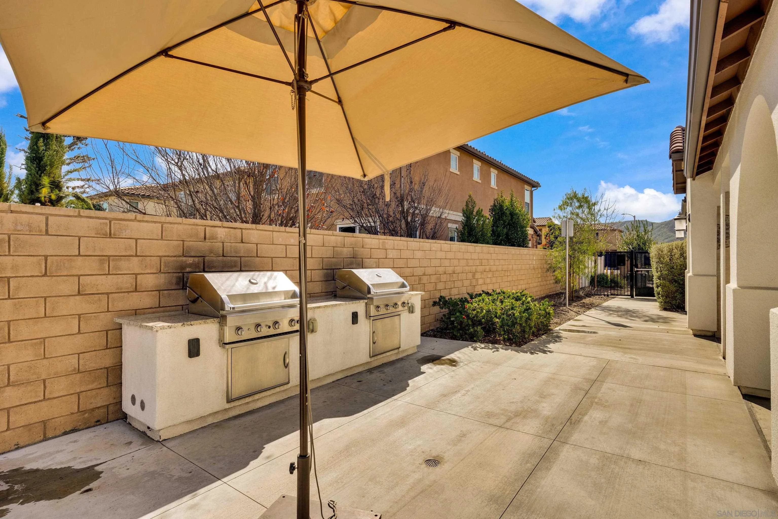 41984 Retsina Street, Unit 705 Murrieta, CA 92562 - Photo 37 of 39 a view of a patio with a table and chairs under an umbrella