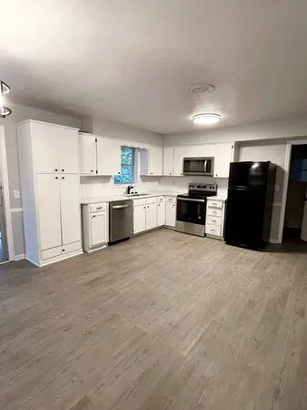 a large kitchen with a stove a refrigerator a sink dishwasher with a dining table and chairs