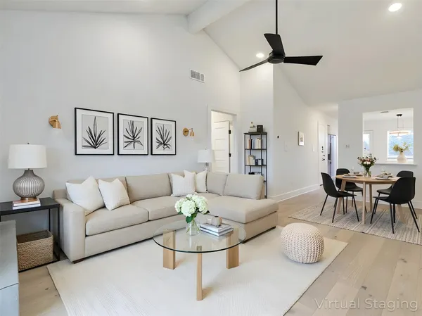 a living room with furniture and a view of kitchen
