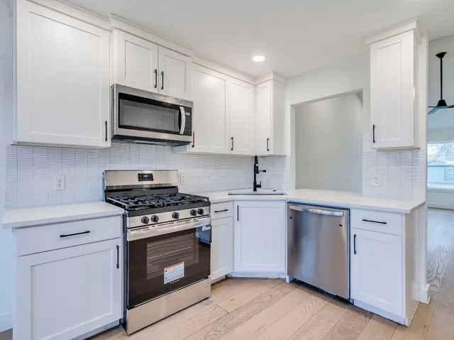 a kitchen with stainless steel appliances granite countertop a refrigerator and a stove