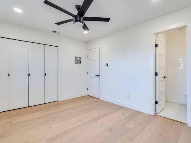 an empty room with a window and a fan