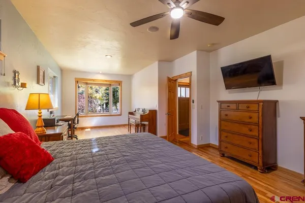 a bedroom with a bed and a mirror on dresser