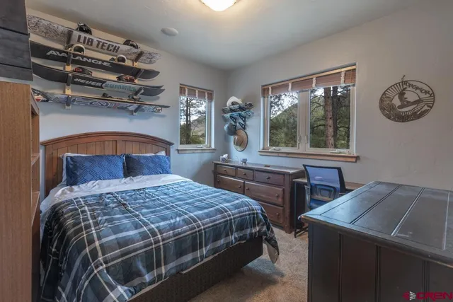 a bedroom with a bed a chandelier and a window