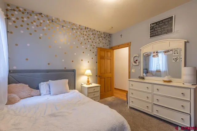 a bedroom with a bed and a mirror on dresser