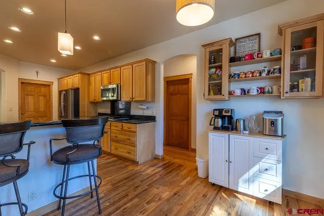 a kitchen with stainless steel appliances wooden floor and cabinets
