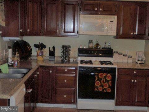 5169 Courtneys Corner Road Sumerduck, VA 22742 - Photo 17 of 29 a kitchen with stainless steel appliances granite countertop a stove a sink and cabinets