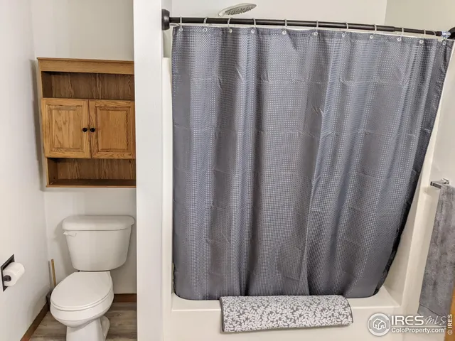 a bathroom with a toilet and a shower curtain