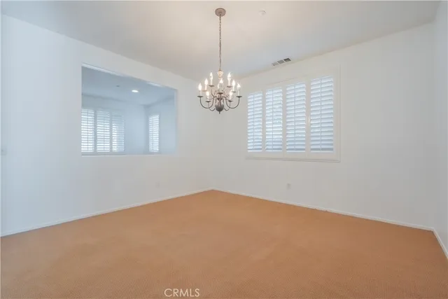 en empty room with windows and chandelier